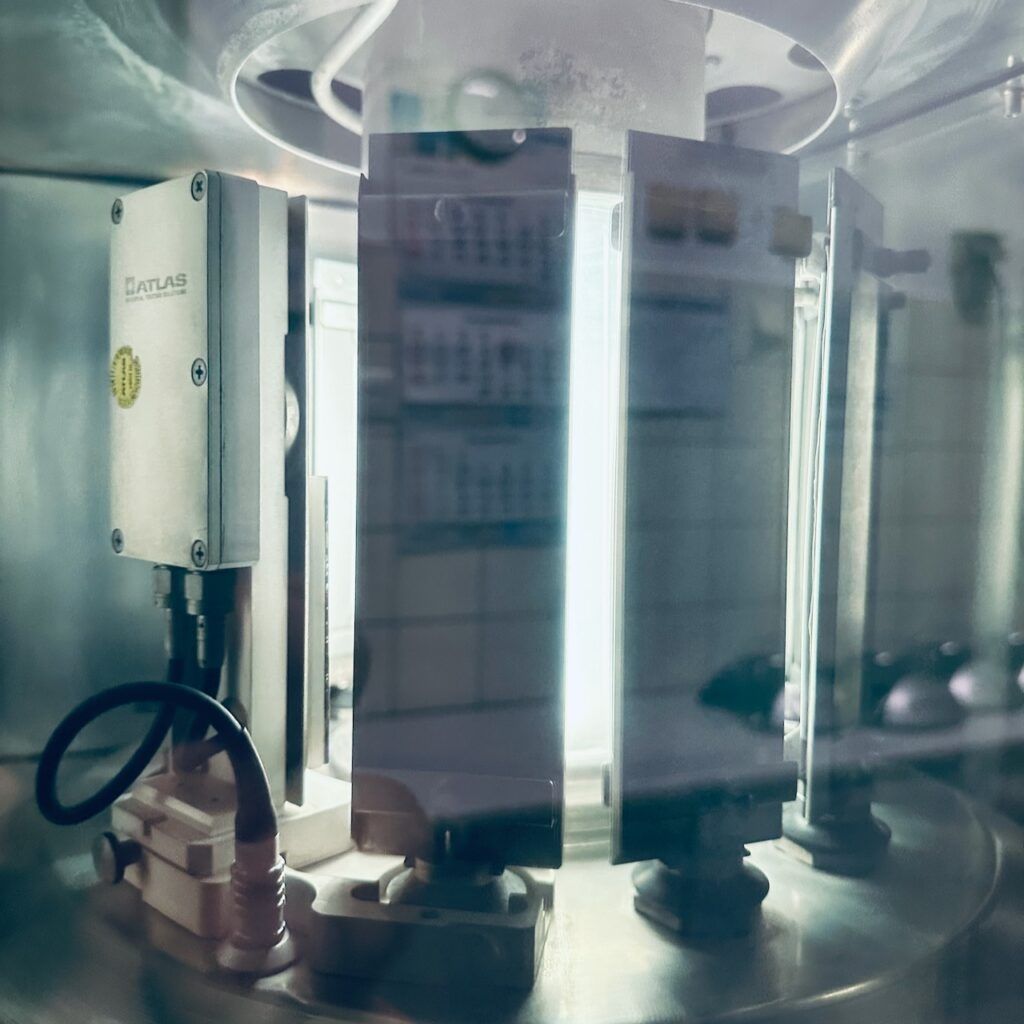 Nahaufnahme eines wissenschaftlichen Geräts mit beleuchteten Tafeln, Sensoren und Kabeln, die eine High-Tech-Umgebung zeigen.