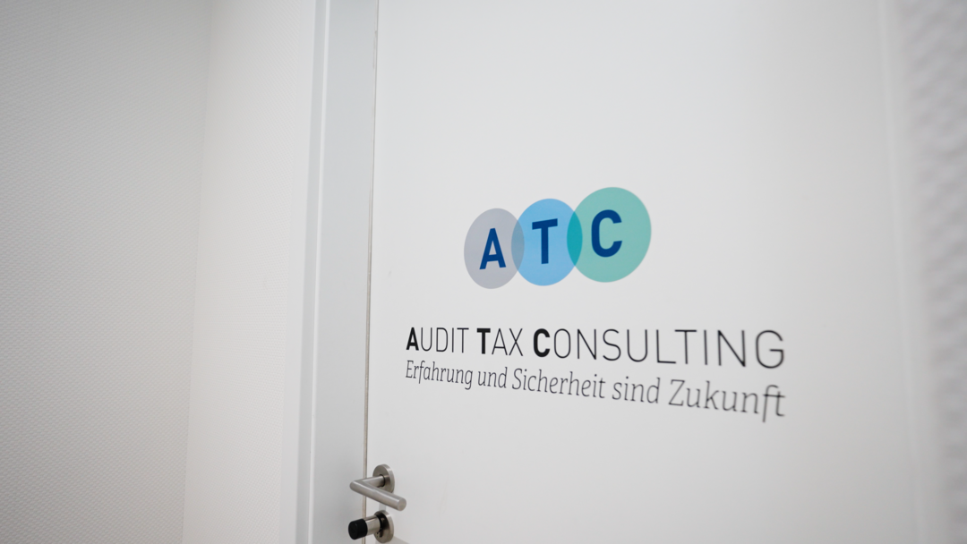 Ein Labortechniker in einem weißen Laborkittel trägt ein Tablett mit Fläschchen mit blauen Kappen zu einem Schrank in einem hellen, sauberen Laborraum.