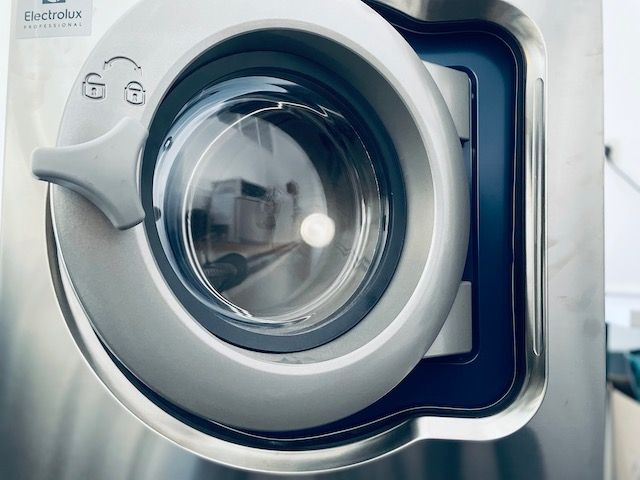 Nahaufnahme einer Electrolux-Waschmaschinentür aus Stahl, die das schlanke Design und das transparente Glasfenster zeigt.